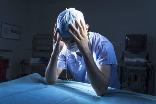 Doctor with his face in palms