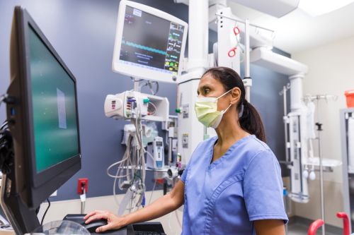 Nurse uses computer to review medical chart